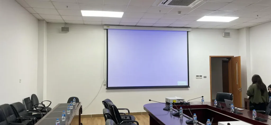 phòng họp hiện đại với màn hình chiếu lớn và bàn hội nghị