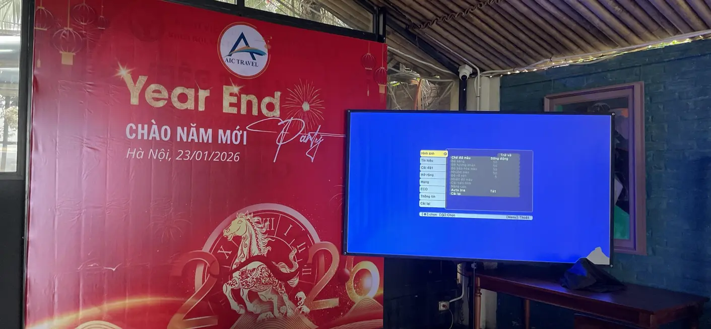 A large LED screen displaying a menu interface in a festive Year End Party setup. The screen is mounted indoors, likely in an event space or restaurant, with a red-themed backdrop for the celebration.